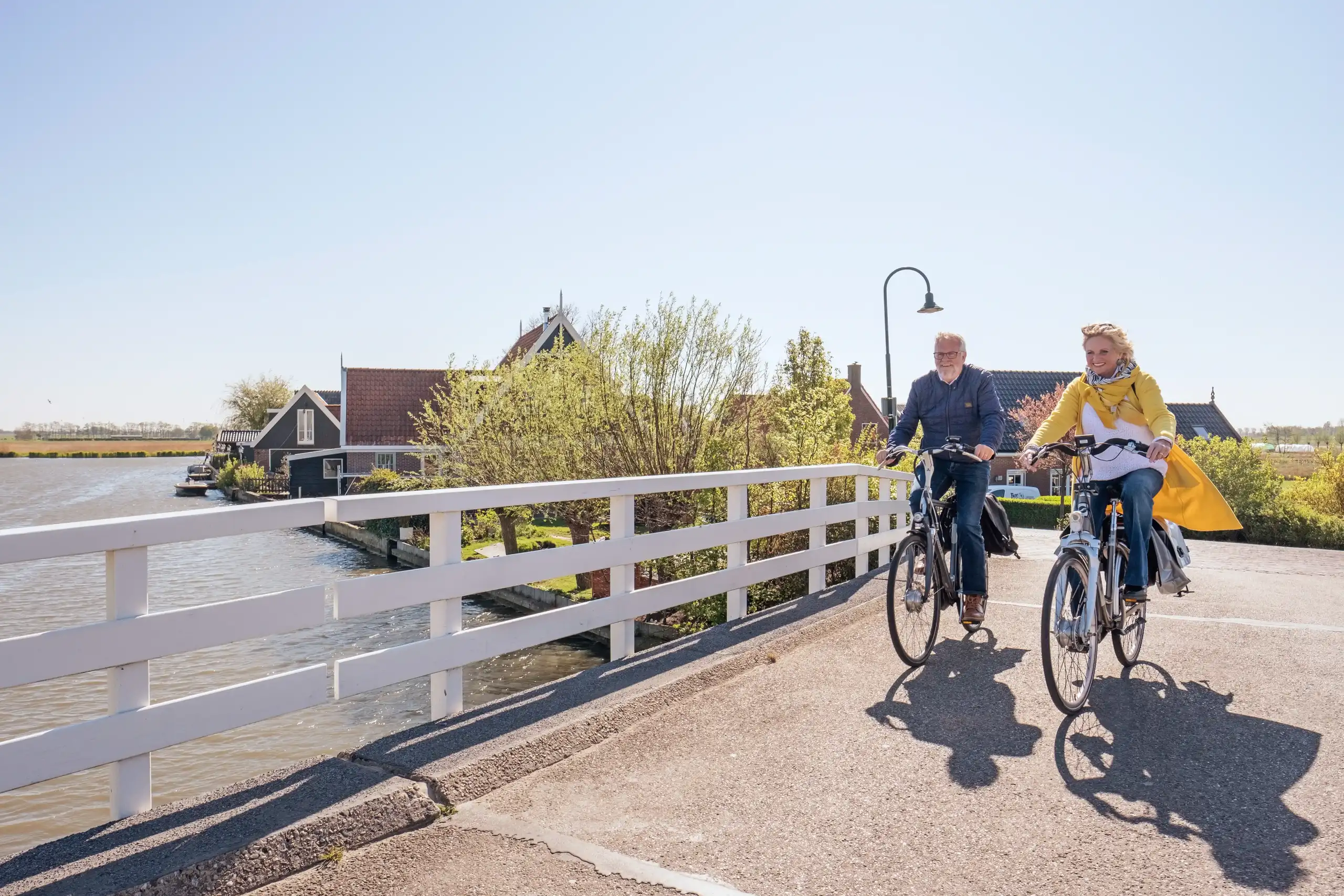 Man en vrouw fietsen over brug